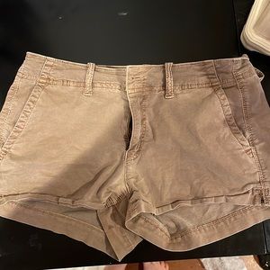 two khaki american eagle shortie shorts and one navy pair . All in a size 4